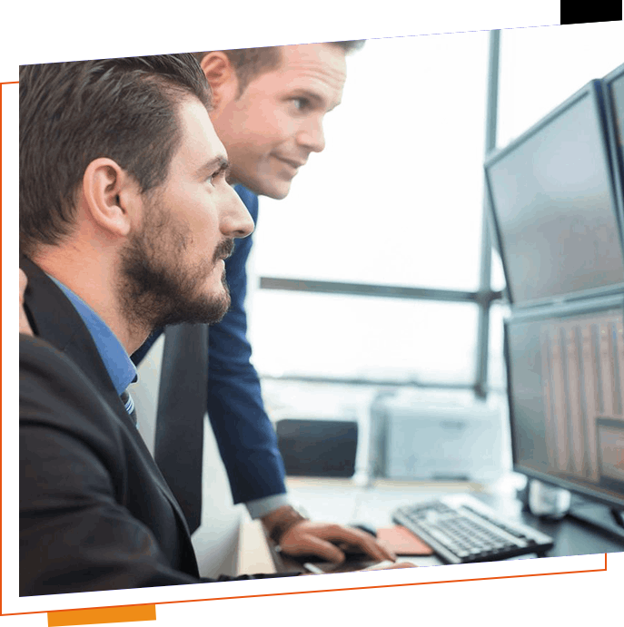 Two men in suits looking at a computer screen.